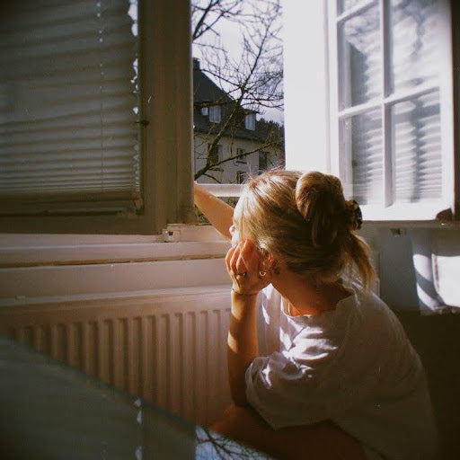women looking out of the window , braing fogged stress and looking for calmness